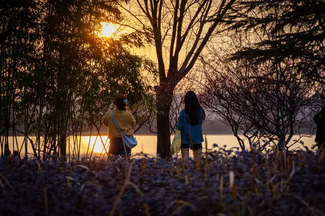 夕阳下的湖畔与行人